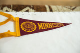 Vintage University of Minnesota pennant, showing gold school seal on maroon felt with tie.