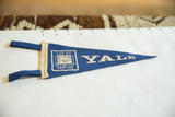 Deep blue felt of vintage Yale pennant with cream YALE lettering and university crest.