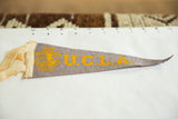Vintage UCLA felt pennant, circa 1950s, showing yellow school seal and creamy side trim.