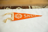 Vintage orange felt pennant with white 'S.H.S.T.C.' lettering and pointed tip.