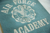 Blue vintage Air Force Academy felt banner with white eagle emblem and textured lettering.