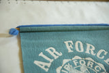 Upper left corner of vintage Air Force felt banner with blue pom-pom and dowel.