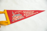 Red felt pennant with yellow binding, 'World's Greatest Indoor Miniature Village' text.