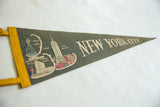 Vintage New York City felt pennant featuring Statue of Liberty illustration and yellow binding.