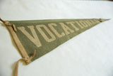 Angled view of a vintage green felt pennant showing its texture and ties.