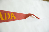 Vintage Canada felt pennant's tapered red end, showing textured felt and yellow 'ADA'.