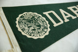 Close-up detail of the Dartmouth pennant's cream seal and dark green felt texture.