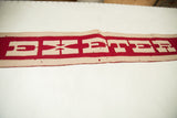 Close-up of vintage Exeter felt banner, showing red and off-white 'EX' letters.