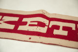 Vintage Exeter felt banner, highlighting appliqued cream letters on red felt with pinholes.