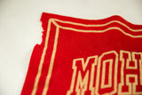 Close-up detail of the worn and frayed corner on the vintage red felt banner.