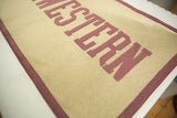 Detail of vintage felt banner: maroon 'ESTERN' letters, tan texture, and stitched border.