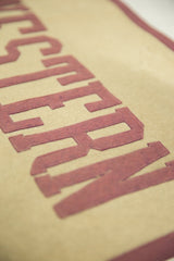 Reddish-brown stitched felt lettering on a light beige vintage Northwestern banner.