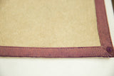 Northwestern felt banner corner with stitched plum border, tan body, minor discoloration.