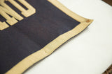 Vintage dark blue felt banner corner with beige trim and reinforced hanging eyelet.