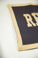 Upper corner of dark vintage felt banner with beige border and small pinhole.