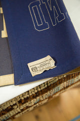 Cream manufacturer tag stitched on the vintage blue felt banner.