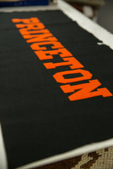 Bold orange felt PRINCETON lettering on black vintage banner, showing felt texture.