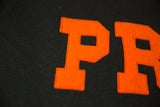 Orange felt 'PR' letters with visible stitching on the dark vintage Princeton banner.