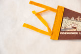 Yellow felt ties and stitched border on vintage brown felt pennant.