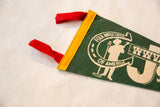 Corner of vintage green felt pennant with red ties, yellow border, and 