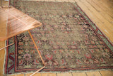 Close-up of worn antique Karabagh rug, showing exposed foundation and faded red, green Herati motifs.