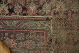 Antique Karabagh rug detail showing exposed foundation, faded Herati pattern, and visible hand-knotted weave.