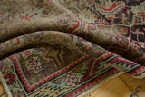 Detail of antique Karabagh rug's worn Herati motif in cherry red, celadon green, with exposed foundation.