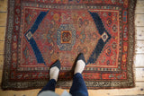 Antique Kurdish rug, circa 1910s, with madder red field, navy stepped medallion, and visible wear.