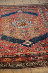 Antique Kurdish rug's madder root red field, navy blue stepped contour, and visible foundation.
