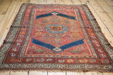 Madder red field, colorful fish motif, and historic edge wear on this antique Kurdish rug.