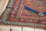 Lower corner of the Antique Kurdish rug, showcasing its intricate geometric border and tattered fringe.