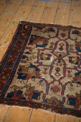 Tattered edge of an antique Lilihan rug, with indigo blue vine border and ivory field palmettes.