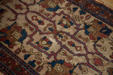 Antique Lilihan rug's ivory field with indigo vinery, oversized palmettes, and even pile wear.