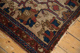 Antique Lilihan rug corner showing worn ivory field, indigo border with botehs, and frayed edges.