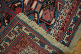 Antique Kuba rug showing original macrame ends and geometric red, blue, ivory motifs.