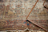 Antique Malayer rug's worn madder red border with sprawling vine and tattered fringe.