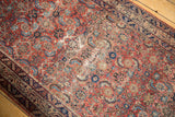 Angled view of an antique Malayer rug's mostly even wear across the red and blue Herati motif.