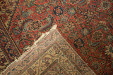 The hand-knotted foundation and cherry red Herati pile of an antique Malayer rug.