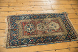 Geometric navy blue and madder red border of an antique Beshir rug, showing secured fringe and wear.