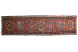 Vintage Karaja runner with madder red field, single column navy geometric medallions, 2'10