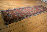 Vintage Karaja runner end, madder root red field, navy geometric patterns, fringe, and visible wear.