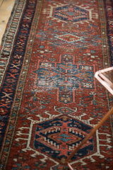 Vintage Karaja runner: navy geometric medallion, madder red field, with visible foundation wear.
