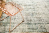 Textural detail of a vintage distressed Sarouk carpet, showing knot heads, exposed foundation, and soft colors.
