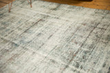 Distressed vintage Sarouk carpet detail, showing exposed foundation and texture in charcoal, purple, ivory.