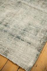Decorative distressed ivory and charcoal Sarouk rug texture with visible foundation and fringe.