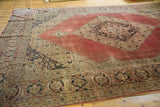 Distressed Jalili Tabriz carpet corner spandrel with blush red and navy floral motifs, showing fresh selvage.