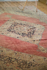 Distressed deep blush red field and navy floral elements showing wear on a Jalili Tabriz rug.