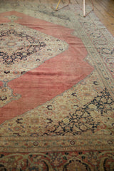 Visible wear on the distressed blush red field contrasting ornate navy and sand spandrel.