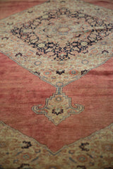 Vintage distressed Tabriz carpet showing blush red field with ornate beige and navy spandrel.