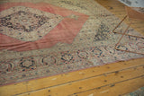 Stylized navy spandrel and border patterns on a distressed blush red Vintage Tabriz rug.